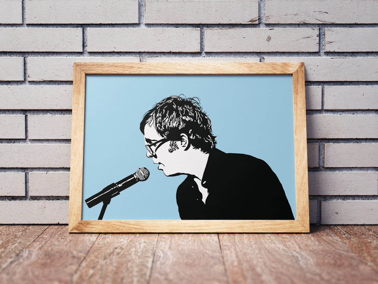 digital minimalist stencil illustration of ben folds singing into a microphone, illustrations is black and white with a light blue background in a wooden frame on the floor leaning against a wall